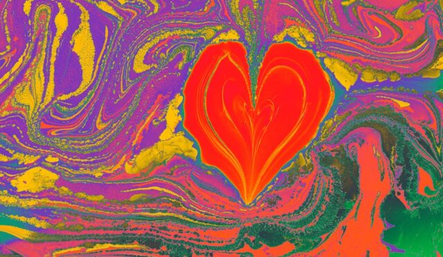 Renkli ebru yaparak oluşturulmuş kalp şekilli, soyut dalgalarla dolu canlı bir sanat eseri.
