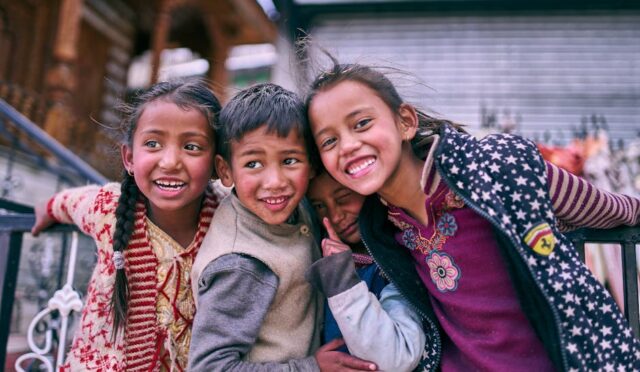 "Mutlu çocuklar, sosyal hayatın önemini gösteren bir grup sarılmasıyla dostluklarını kutluyor."