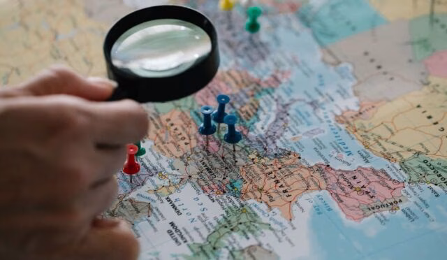 Büyüteç, dünya haritasında seyahat rotalarını vurgulayan pinlere odaklanıyor. 2026'da nereye gitmeliyim?